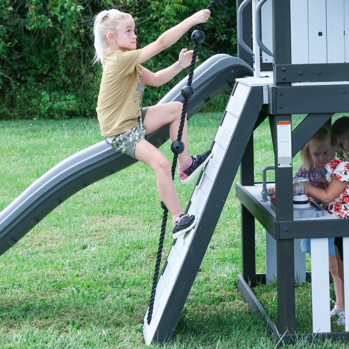 Backyard Discovery Whispering Point Light Gray Cedar Wood Swing Set with Wave Slide, Clubhouse, Crows Nest, Play Kitchen, Belt Swings, Web Swing, Rock Wall, Playhouse, Ladder, Windows, Outdoor Playset